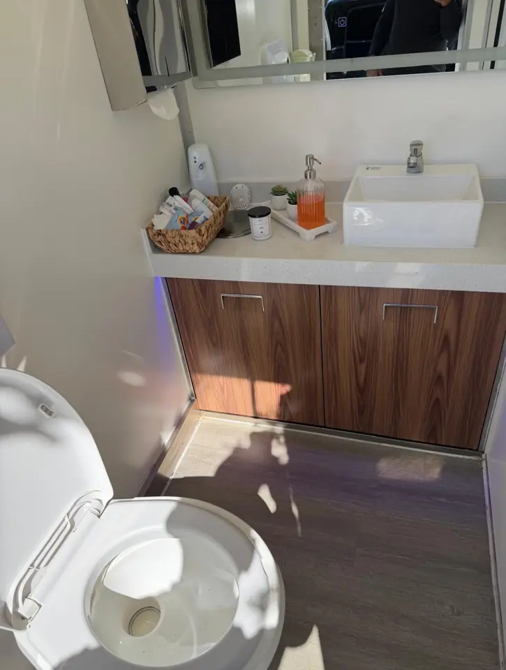 Wood vanity with vessel sink in a luxury restroom trailer