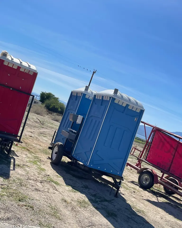 Portable toilets on a trailer at an open field site