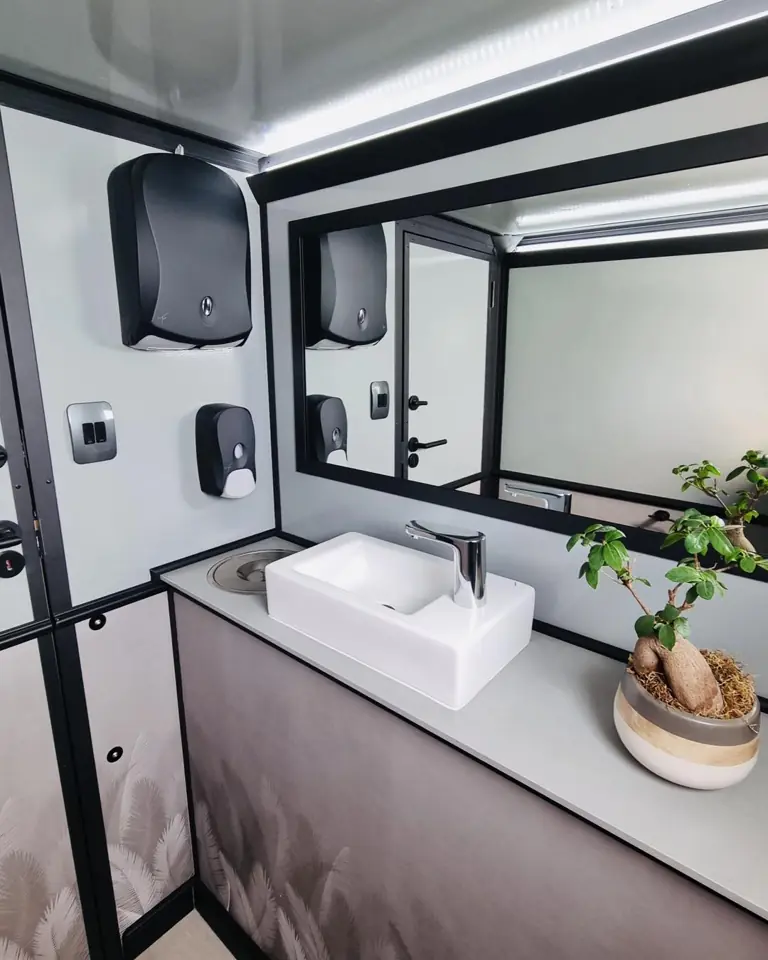 Restroom trailer vanity with vessel sink, mirror and dispensers