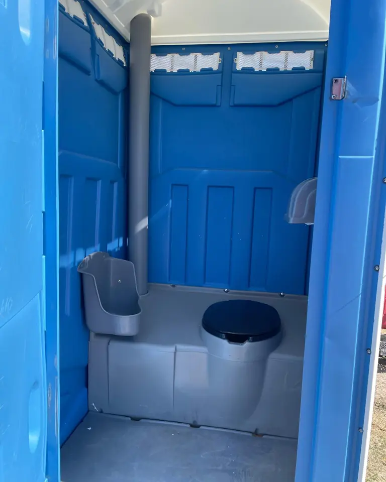 Inside a blue standard porta potty showing the seat and urinal